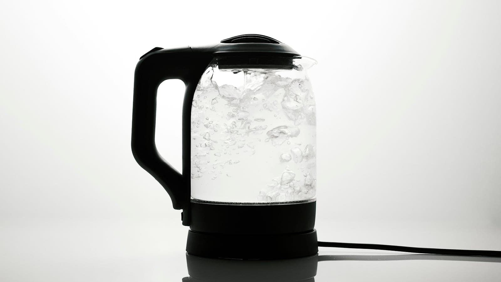 Un bollitore elettrico di vetro con l'acqua in ebollizione