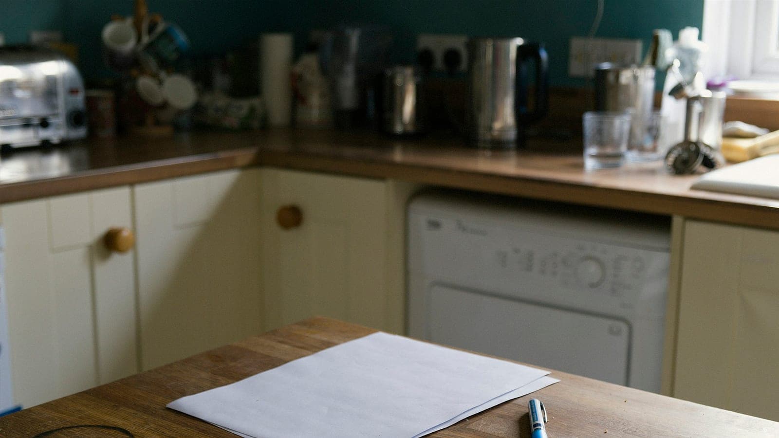 Un foglio bianco e una penna sul piano di una cucina